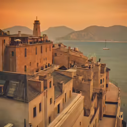 a brown building in front of water at sunset