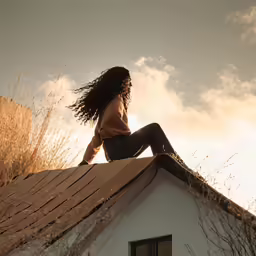 a girl is sitting on the roof of a building