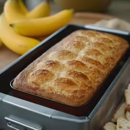 some baked bread on top of a pan next to bananas