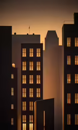silhouetted buildings and building with light coming from the windows