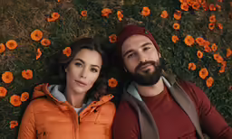 a couple poses for a photo near flowers
