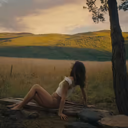 the woman is sitting on the wood in the woods