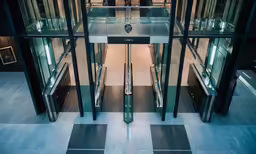 a view of a glass enclosed hallway that is in a building