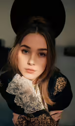 a girl is looking away while she wears a black hat