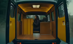 the rear section of a yellow van with the door open