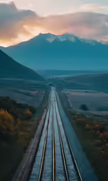 a railroad track runs along one end of the mountain pass