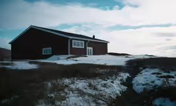 the cabin is in the middle of a snowy field
