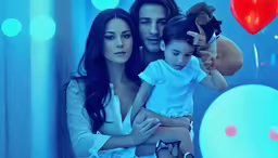 a family posing in front of balloons with one woman holding her