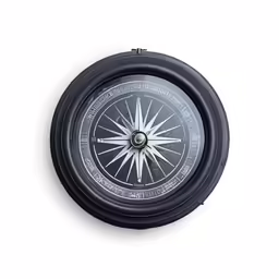 a black and white compass on a white wall