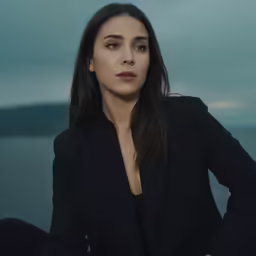 the woman is sitting on a pier by the water