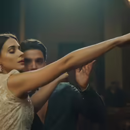 the man is wearing a suit and tie is dancing
