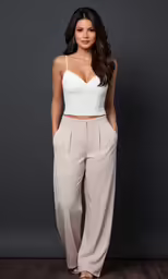 a woman posing for a picture in pants and a bra top