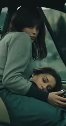 a woman taking a picture of another person laying down