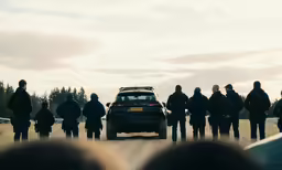 a group of police officers standing around a car