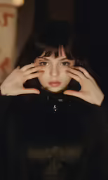 a girl with hand on her face holding something