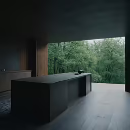 an empty counter sits by a large window in a dark room