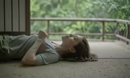 a woman with braids on her head laying on a rug