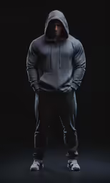 a young man standing in a dark hoodie
