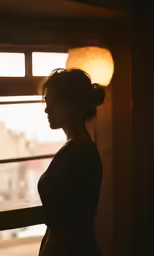 the woman in black is standing near a window