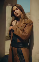 a young woman wearing a trench coat and black leather pants