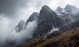 a couple of mountains with some clouds and fog