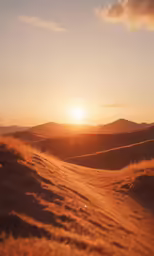 the sun is setting over the desert hills