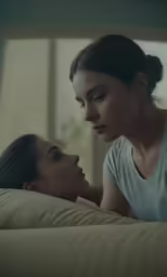 a woman looking at another woman sitting on a couch