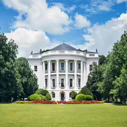a large white building with many trees around it