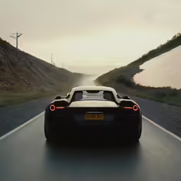 the rear end of a car that is driving down a road
