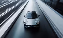 a white car is shown from above as it drives down the road