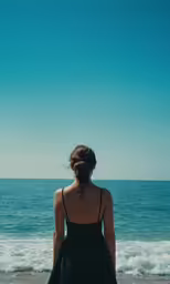 a person on the beach looking at the ocean