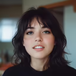 a woman with dark hair is posing for the camera