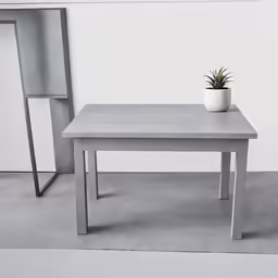 a cement table with a plant on it and two chairs