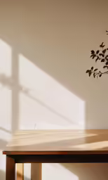 a wooden table sitting under a tree next to a wall