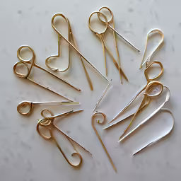 several pairs of golden scissors in different sizes and sizes on a marble surface