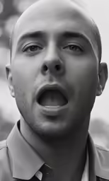 man with open mouth in black and white photograph