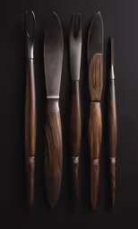 a collection of four different wooden knives and a fork