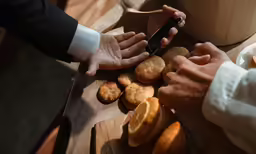 three people cutting some kind of food