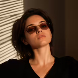 a woman with glasses standing in front of the sun
