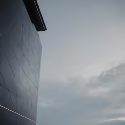 the side of an office building with cloudy sky