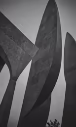 a couple of tall curved objects next to trees