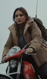a woman sitting on the back of a red motorcycle