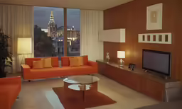 a modern living room has an orange sofa and love seat