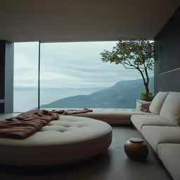 an unusual circular shaped couch next to a large window