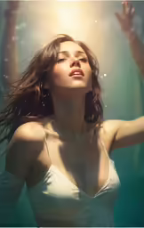a woman is in water with her hands raised