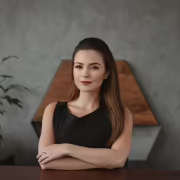 a beautiful woman sitting at a table in an office