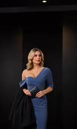 woman in blue dress standing in an empty room