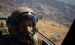 a male with an oxygen mask is looking out the cockpit