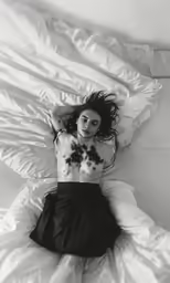 black and white photo of a woman laying on a bed