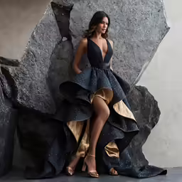 a model posing on the rock wearing a black gown